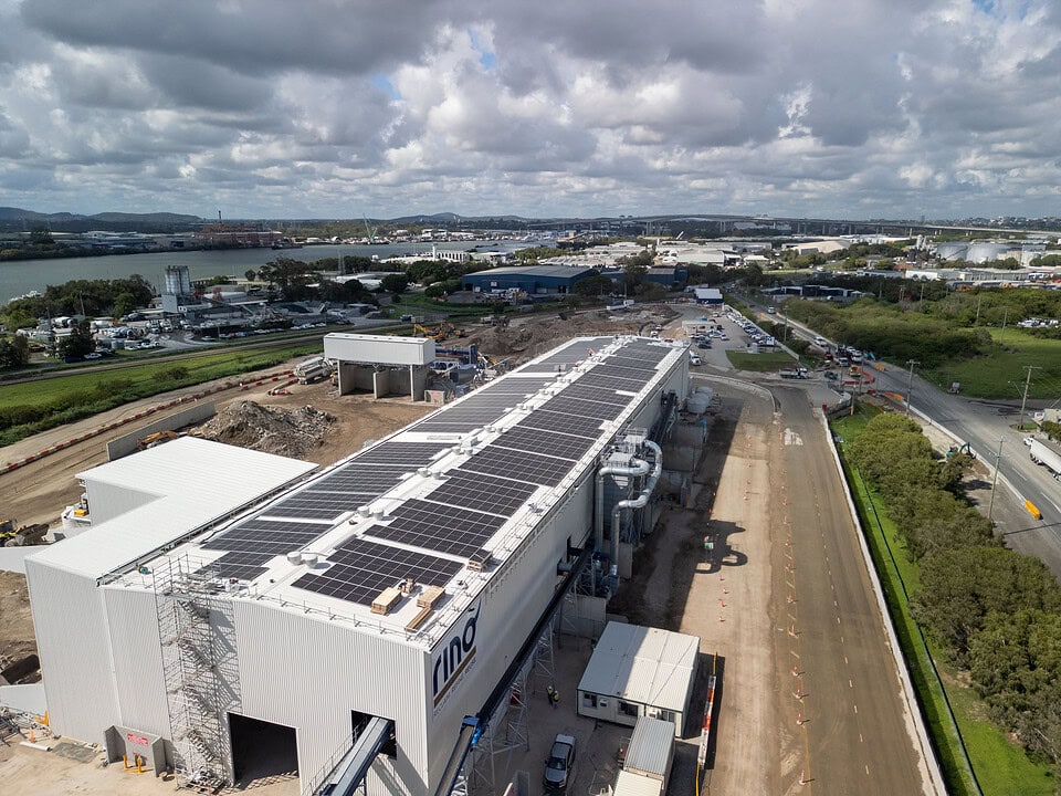 Aerial drone view of the Rino Recycling Facility under construction in Brisbane, showing solar panels installed on the industrial roof and surrounding site works.