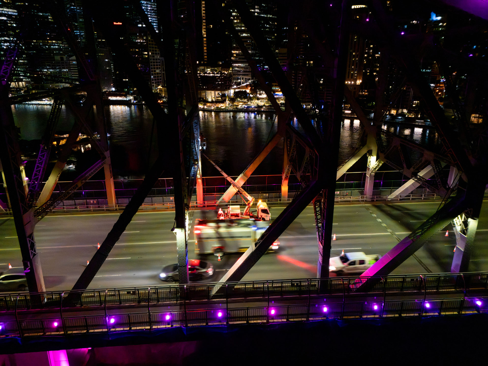 Aerial drone view of LINCON trucks operating in a closed lane on Story Bridge during night infrastructure works.