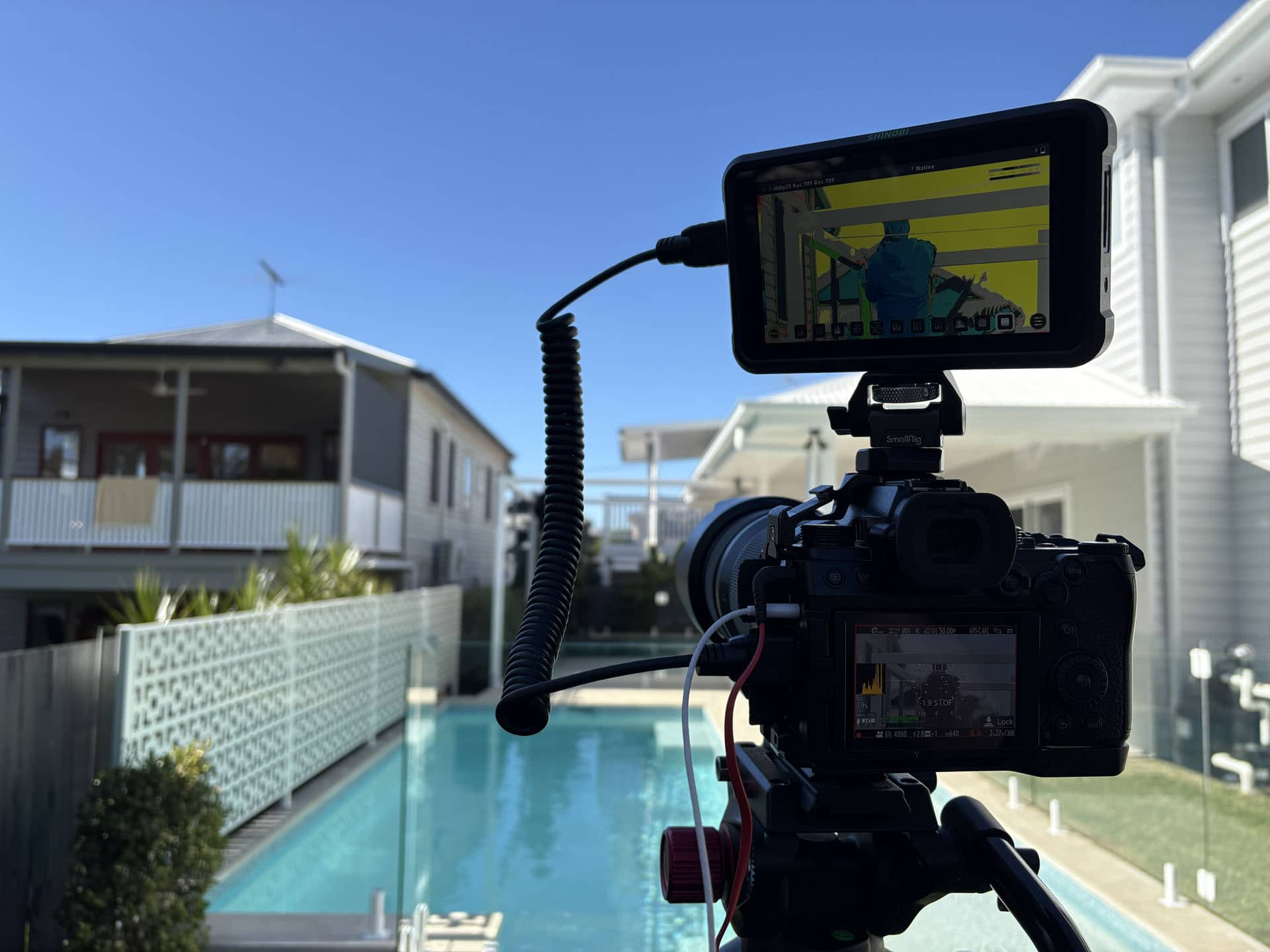 Cinema camera filming outdoor lifestyle video near swimming pool location