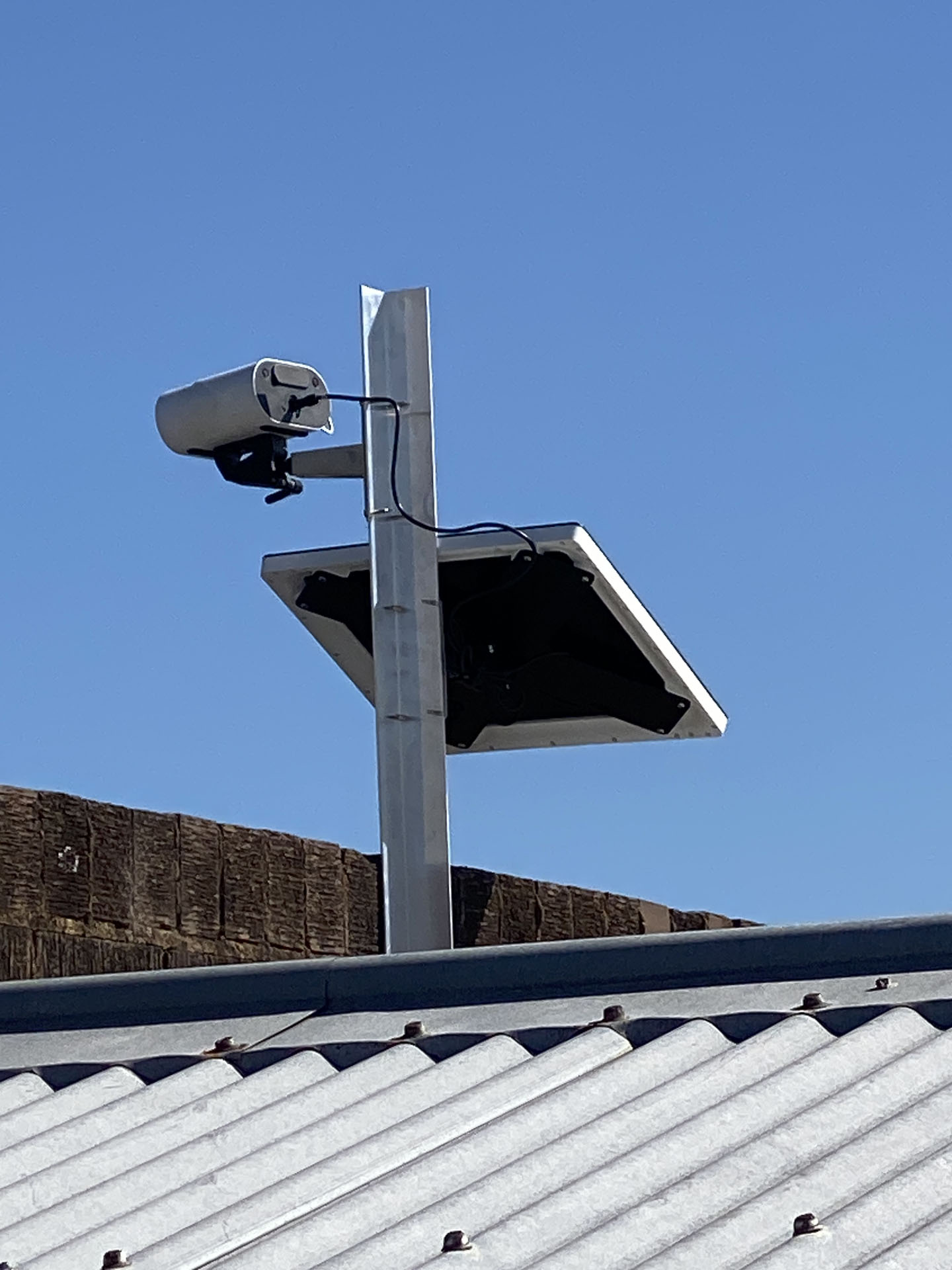 Solar powered timelapse camera mounted on pole for remote site monitoring