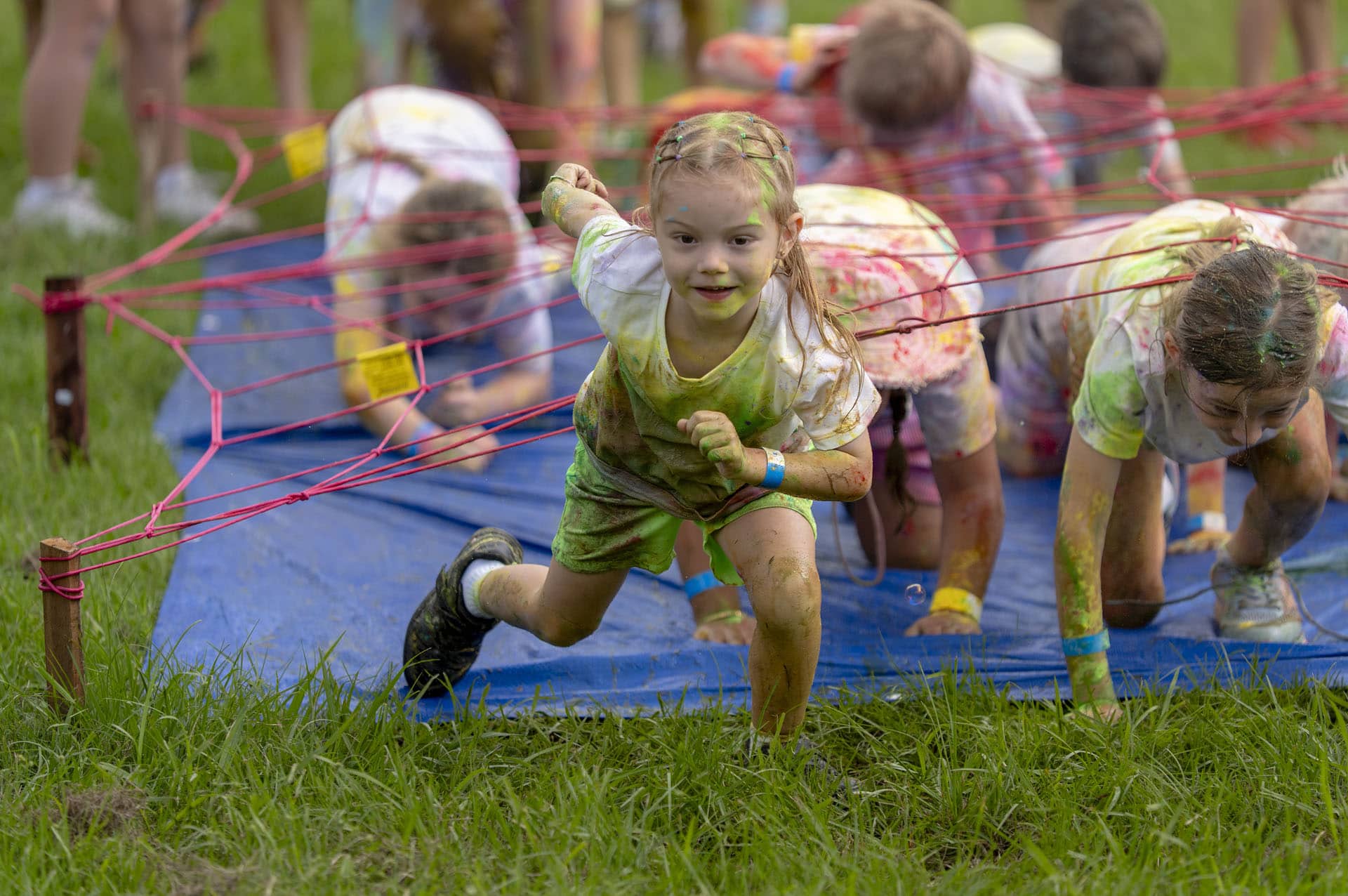 Child crawling through obstacle activity during PCYC Crestmead Colour Run event in Crestmead, Queensland.