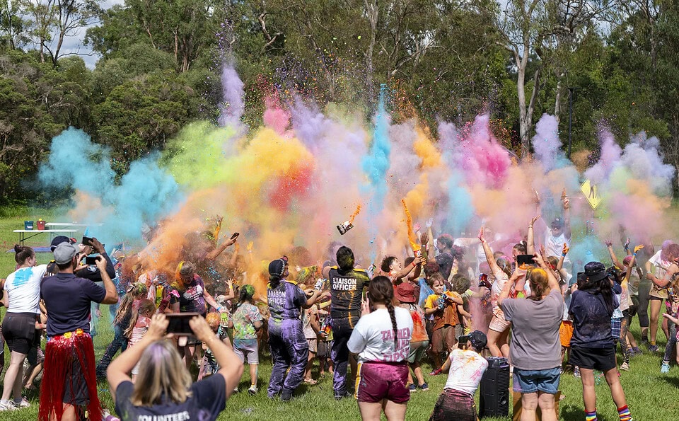 Wide shot of colourful chalk explosion during PCYC Crestmead Colour Run charity event in Crestmead, Queensland.