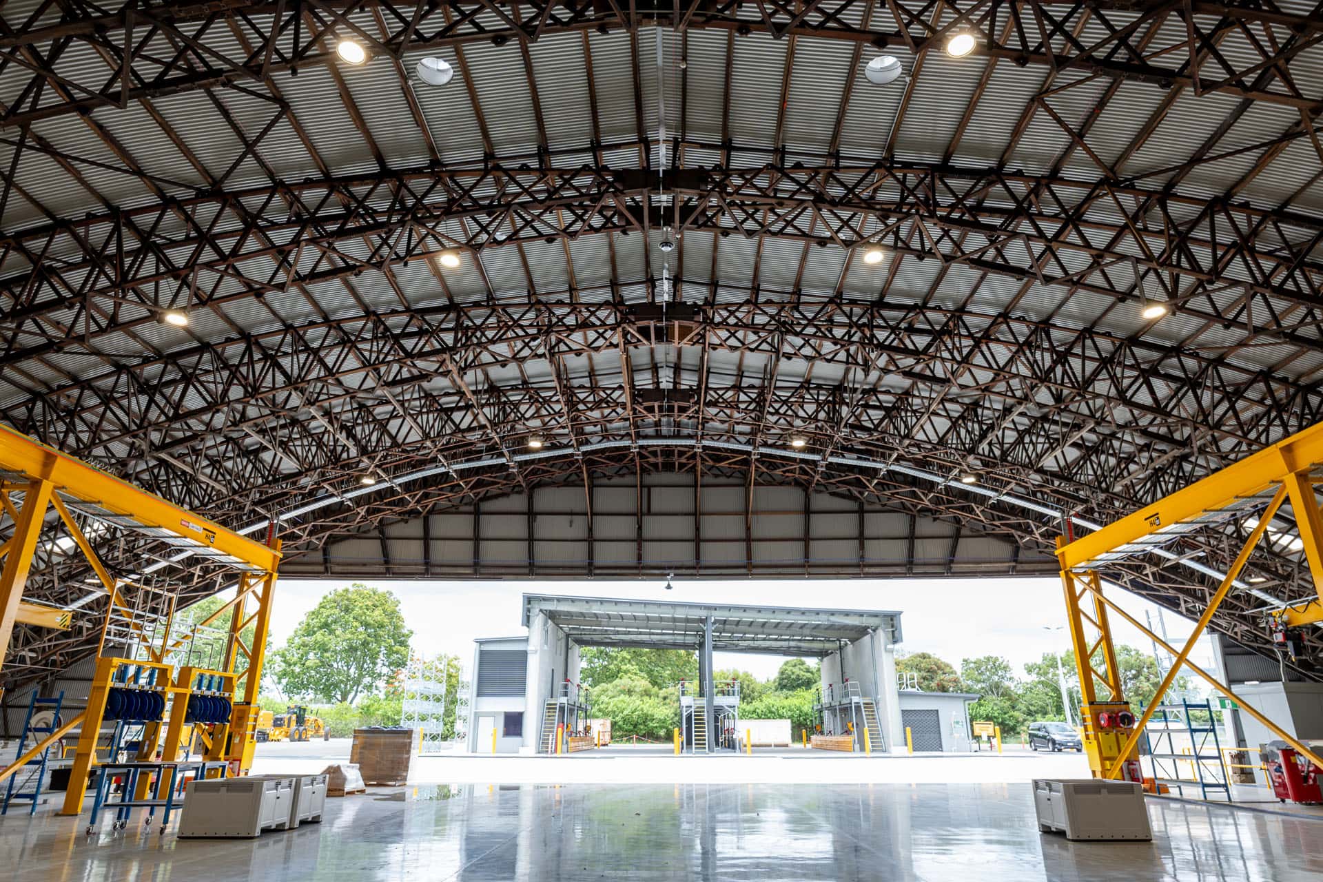 Wide interior view of heavy machinery workshop in Archerfield, Queensland showing structural steel framing and plumbing installation.