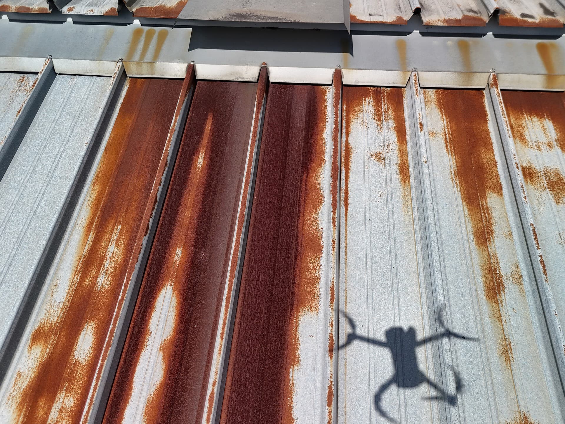 Close aerial inspection photograph showing extensive corrosion on metal roof sheets at Brisbane Markets